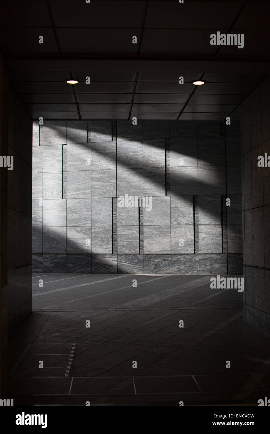 Sonnenlicht strömt Licht auf eine graue Steinmauer einen Fußgängerweg in Shinbashi, Tokio, Japan. Stockfoto