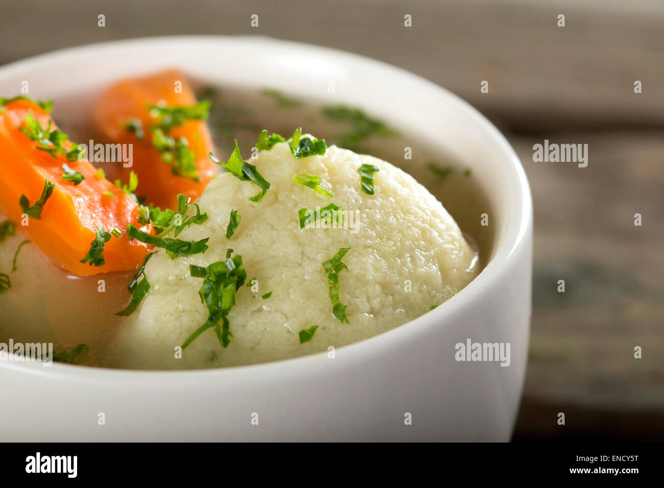 Nahaufnahme eines traditionellen Huhn Suppe mit Knödeln auf einem rustikalen Holztisch Stockfoto