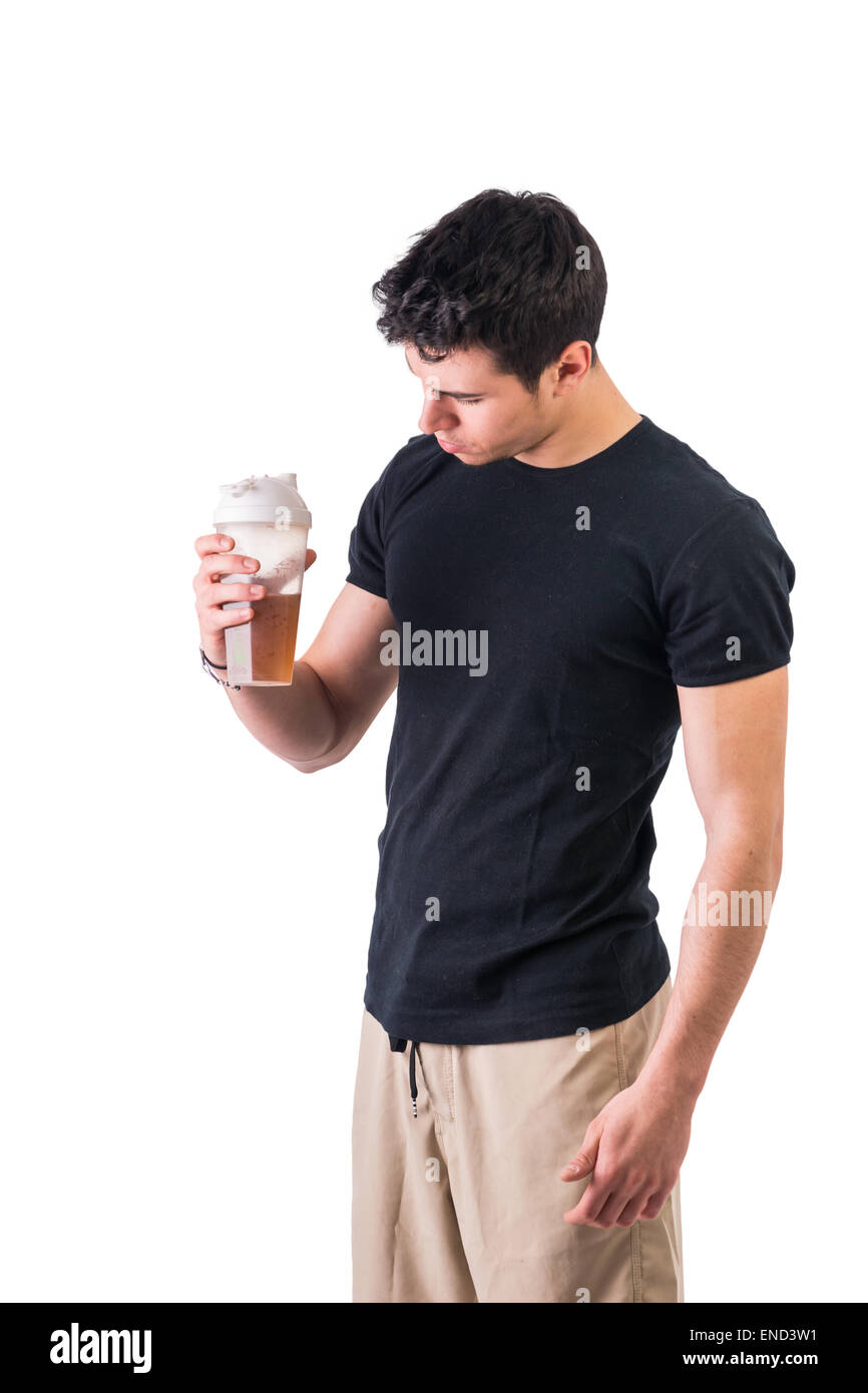 Attraktive junge Mann, der Protein Shake Flasche hält Stockfoto