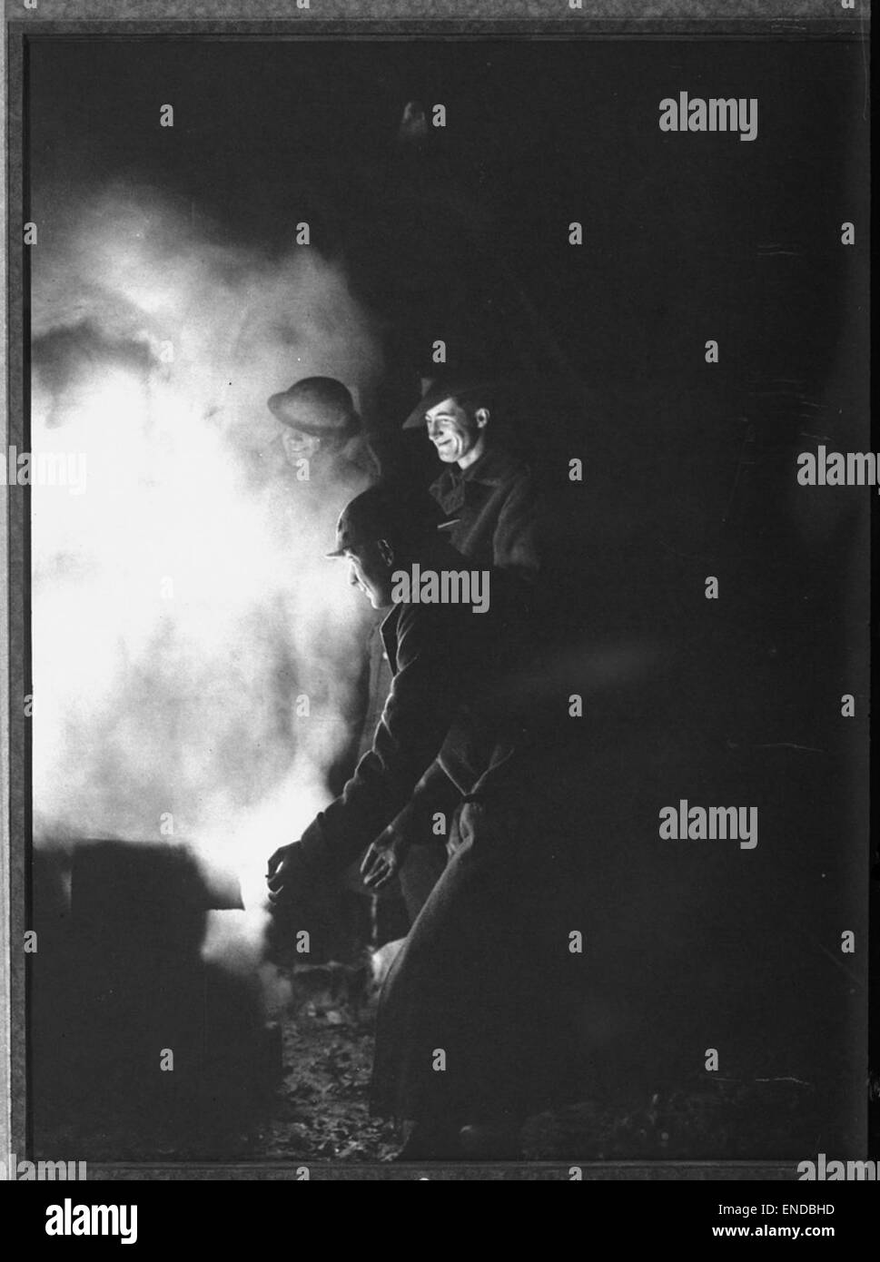 Dieses Foto zeigt australische Infanteristen, die sich während des Krieges um ein Lagerfeuer hinter der Front versammelt haben. Es zeigt die Kameradschaft und die Momente der Ruhe in einer rauen und anspruchsvollen Umgebung. Stockfoto