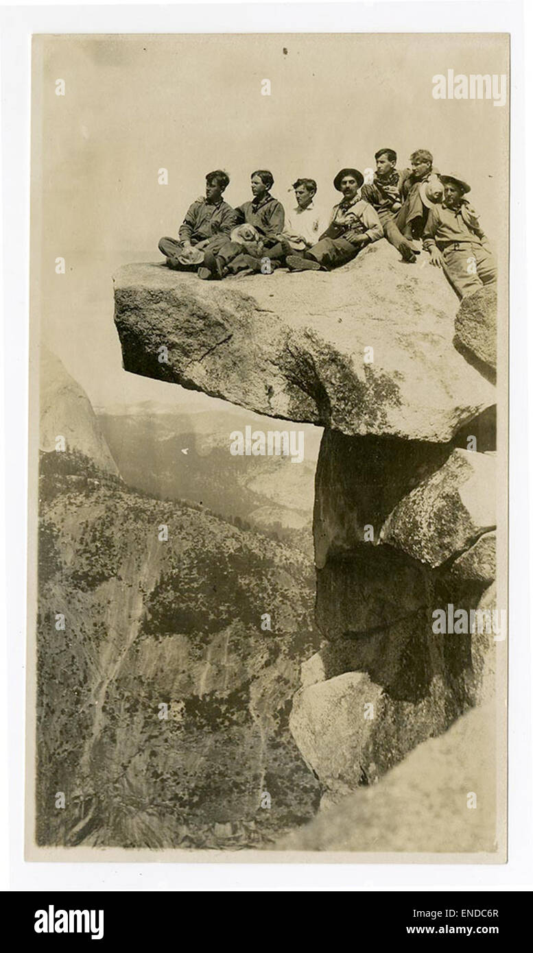 [Gruppe von Männern sitzt auf überhängenden Felsen, Glacier Point, Yosemite] Stockfoto