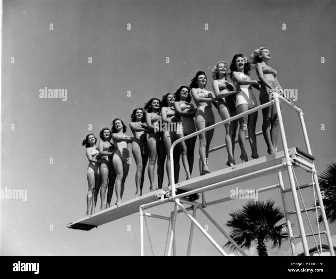 Eine Gruppe junger Frauen steht auf einem Tauchbrett in Sankt Petersburg und bereitet sich auf einen Tauchgang ins Wasser vor. Dieser Moment fängt ein Gefühl von Sport und Freizeit in einer historischen Stadt ein, in der die Kultur des Outdoor-Sports und der Erholung gefeiert wird. Stockfoto