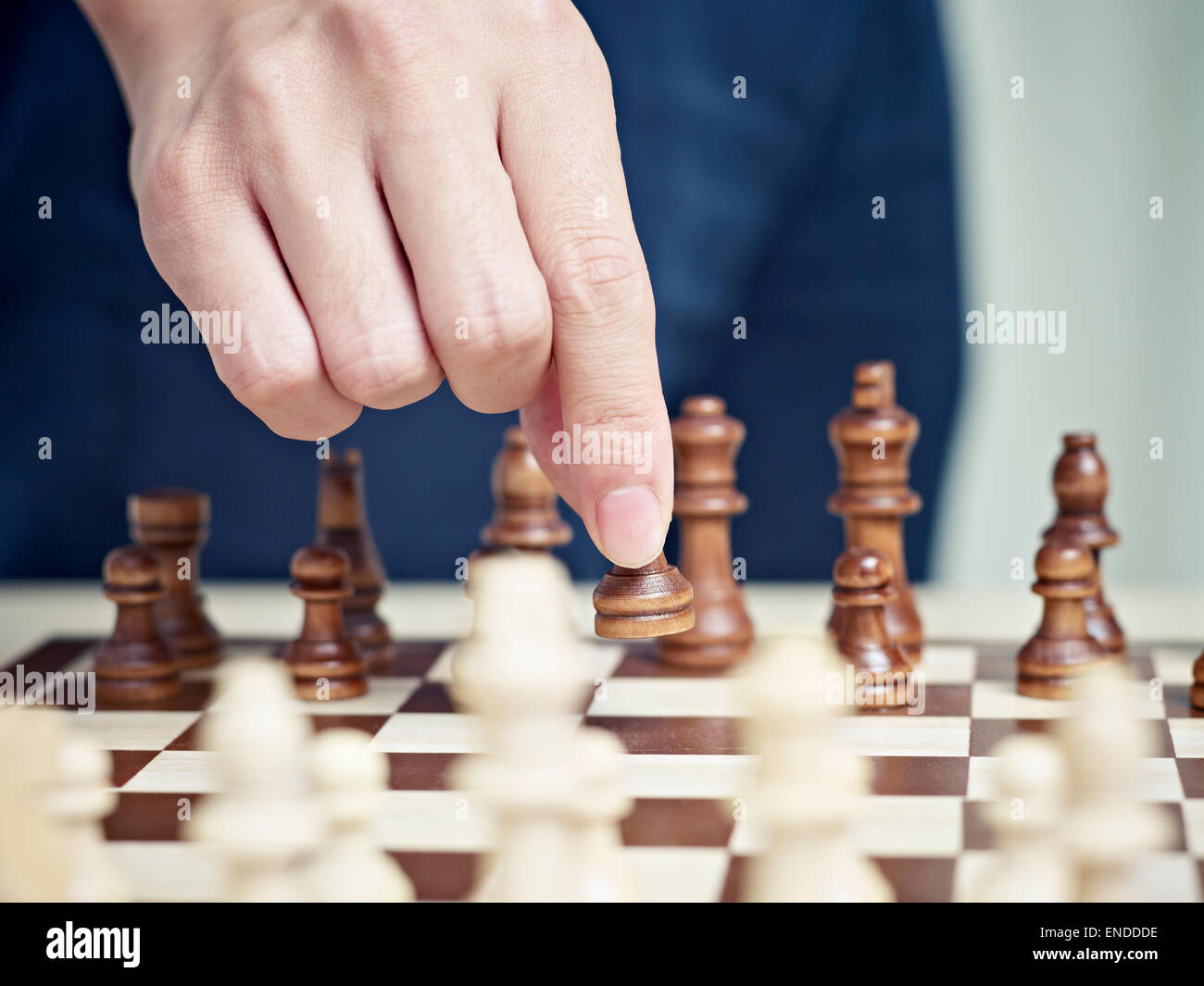 Hand bewegt eine Schachfigur Stockfoto