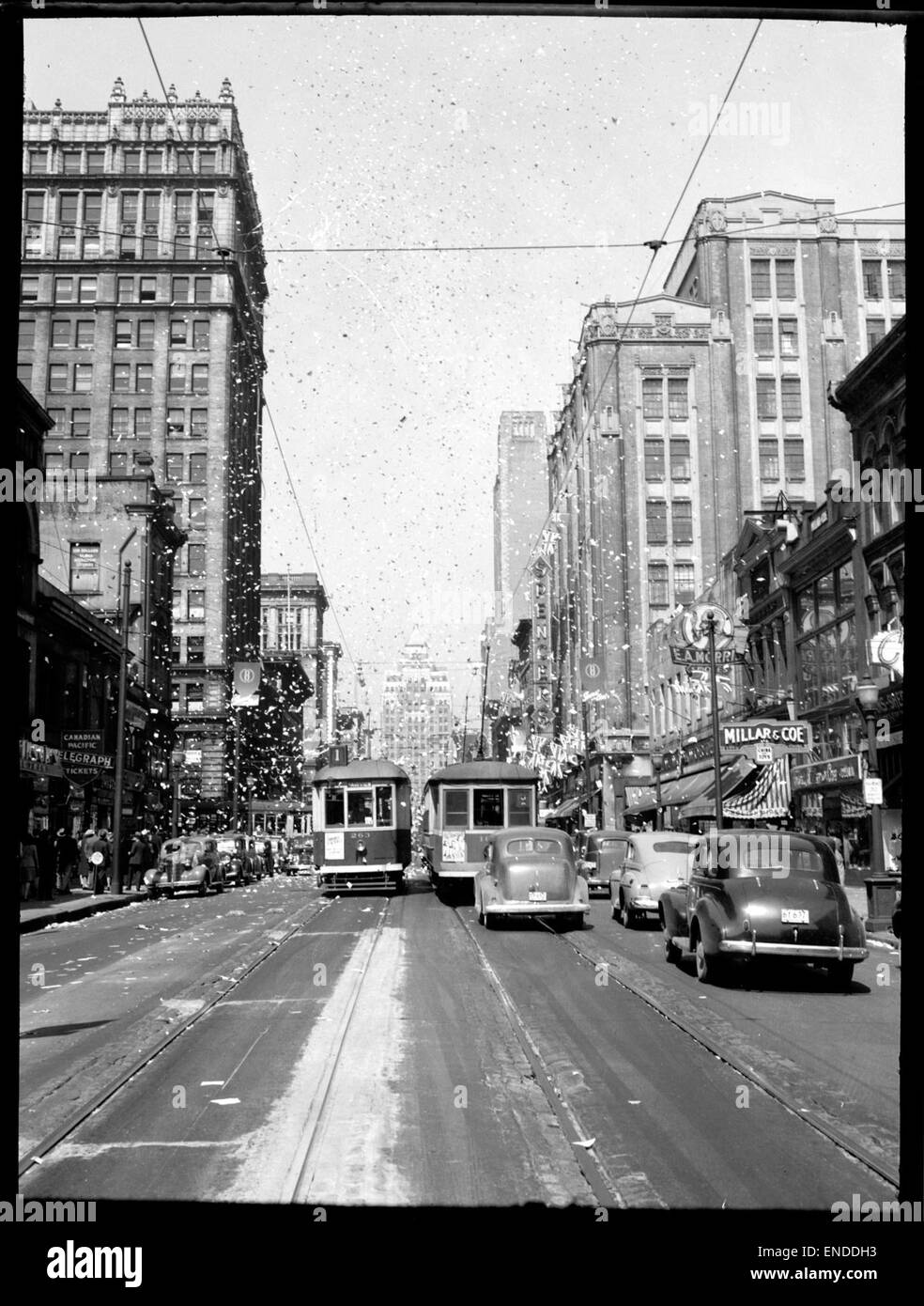 Dieses Foto fängt die Spannung des *V-E Day* ein, während das Klebeband am 8. Mai 1945 über die Menschenmassen fällt, um das Ende des Zweiten Weltkriegs in Europa zu feiern. Die fröhliche Atmosphäre symbolisiert Sieg und Frieden. Stockfoto