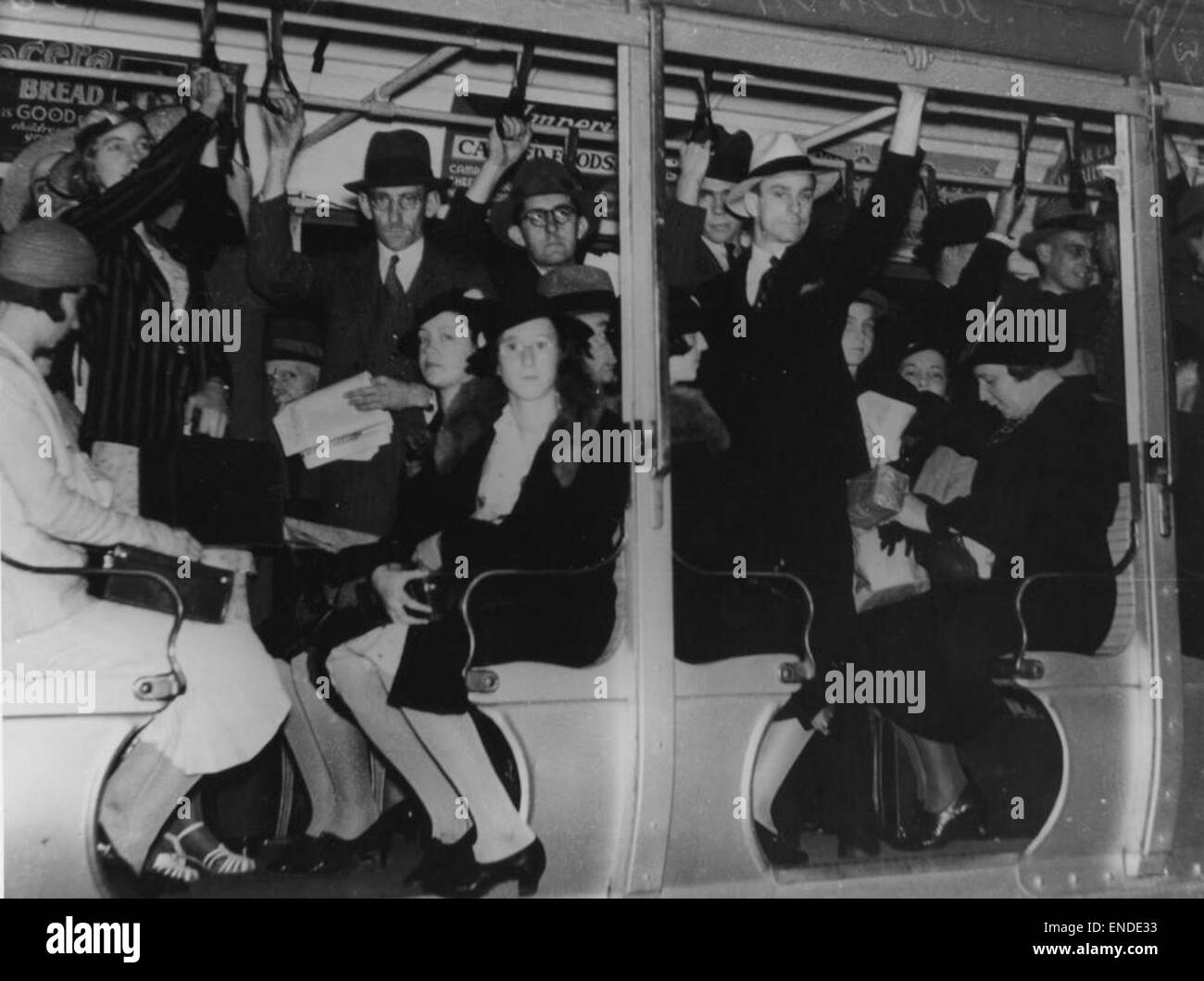 Ein Schwarzweiß-Foto aus dem Jahr 1937, das Passagiere mit Gurtbügeln in einer überfüllten Straßenbahn in Brisbane zeigt und einen Einblick in die öffentlichen Verkehrsmittel der Mitte des 20. Jahrhunderts bietet. Stockfoto