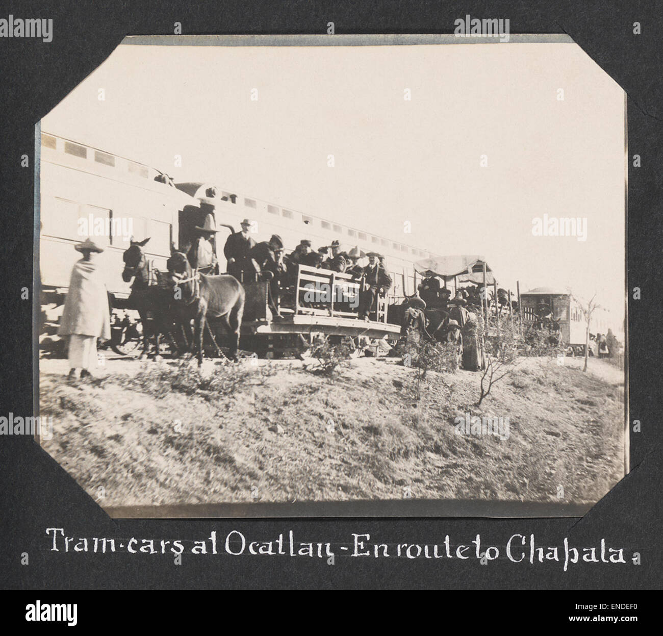 Ein historisches Foto von Straßenbahnwagen auf dem Weg nach Chapala von Ocatlan, begleitet von Karren, Eseln, Trolleys und Waggons. Das Bild zeigt Transportmethoden des frühen 20. Jahrhunderts im ländlichen Mexiko. Stockfoto