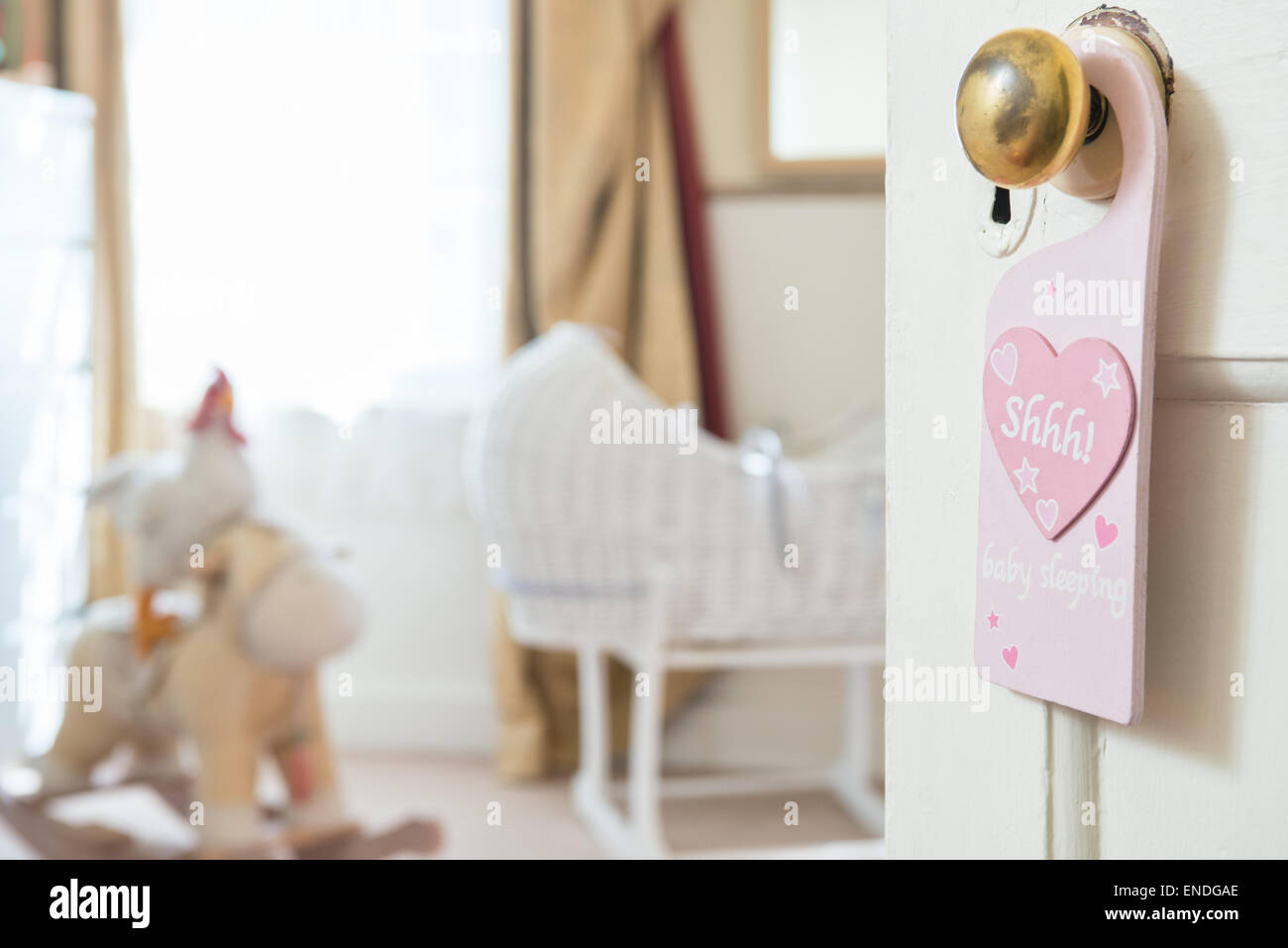 Eine offene Tür in ein Babys Kinderzimmer Schlafzimmer hängt ein Zeichen aus einem Messing-Türgriff mit dem Motiv "Shhh" geschrieben in einem rosa Herzen Stockfoto