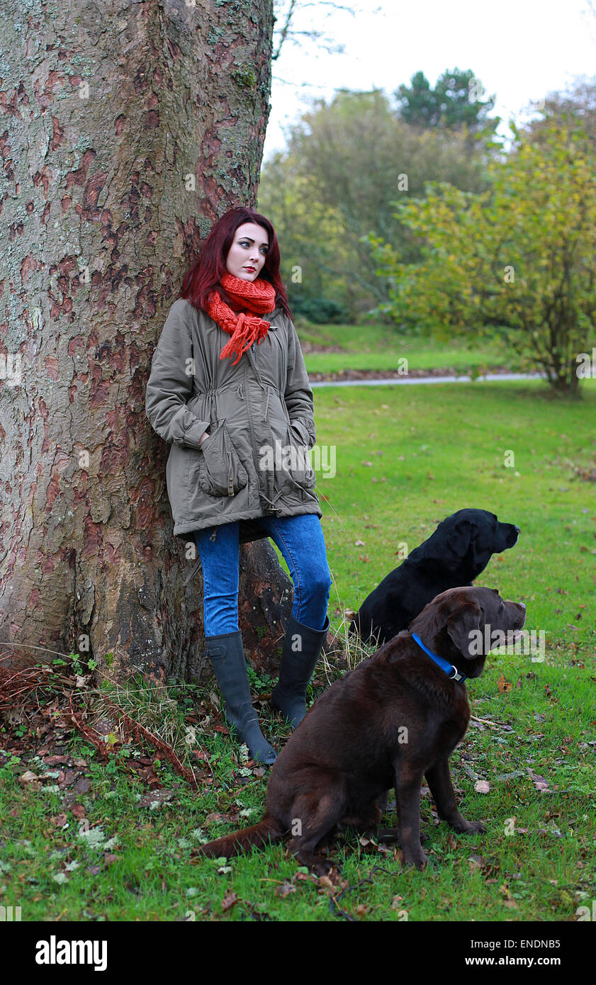 Schöne junge Frau im Freien mit ihren beiden Hunden Stockfoto