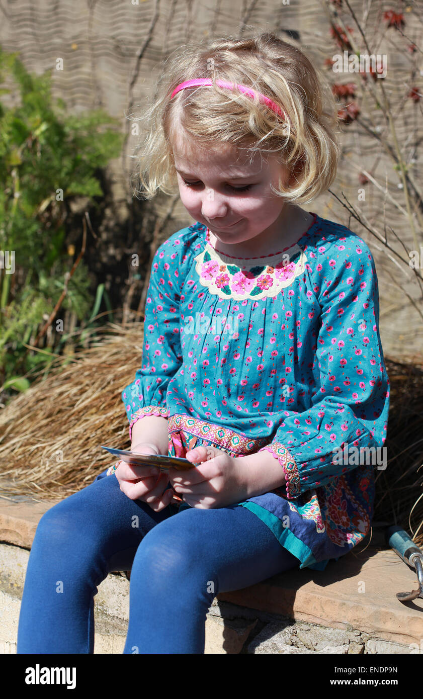 Hübsches junges Mädchen Blick auf ein Paket von Samen in einem Garten Stockfoto