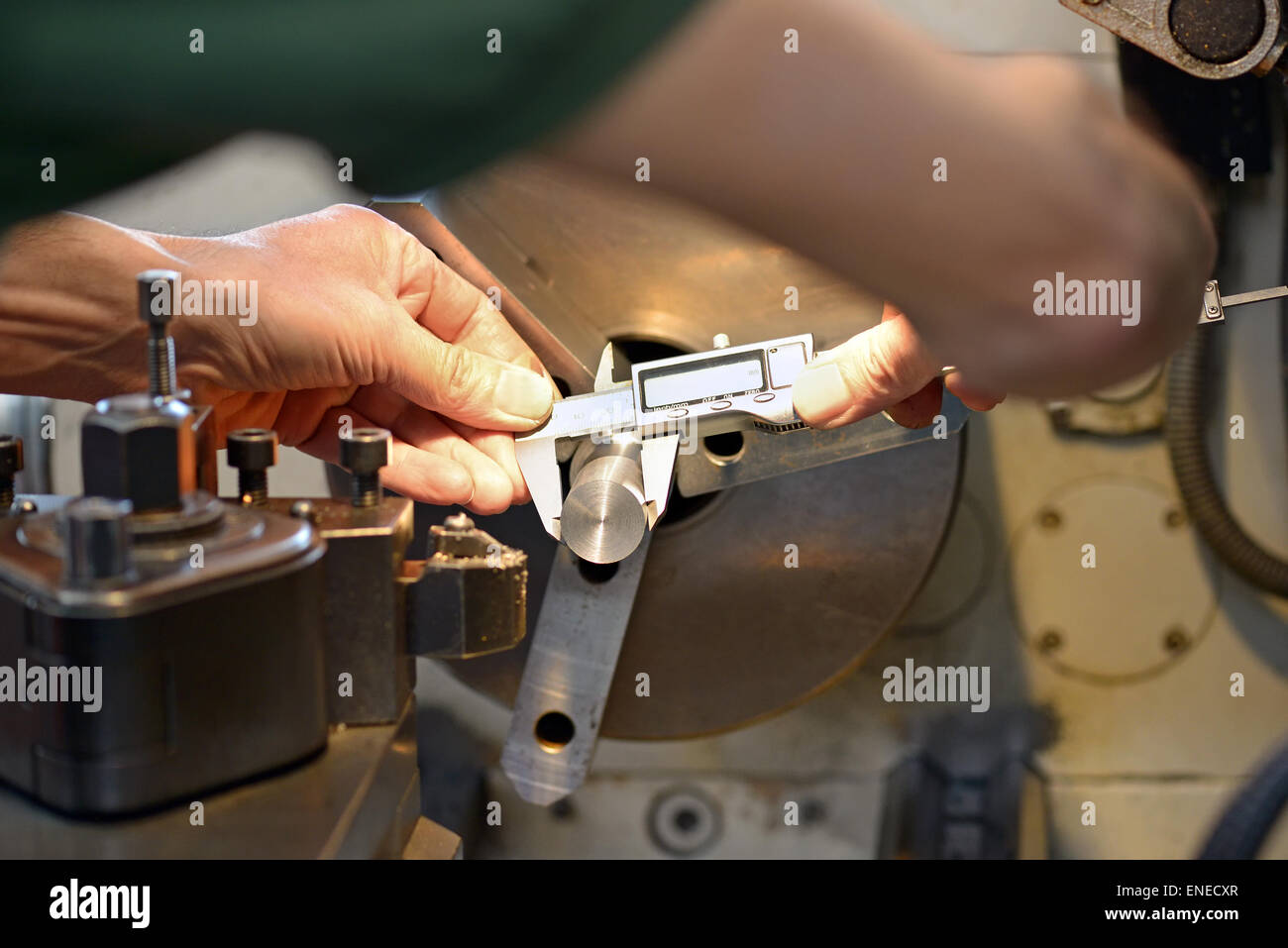 Händen des männlichen Maschinenbauingenieur während der Messung einer metallischen Stück mit einer genauen Bremssattel an Werkbank Stockfoto
