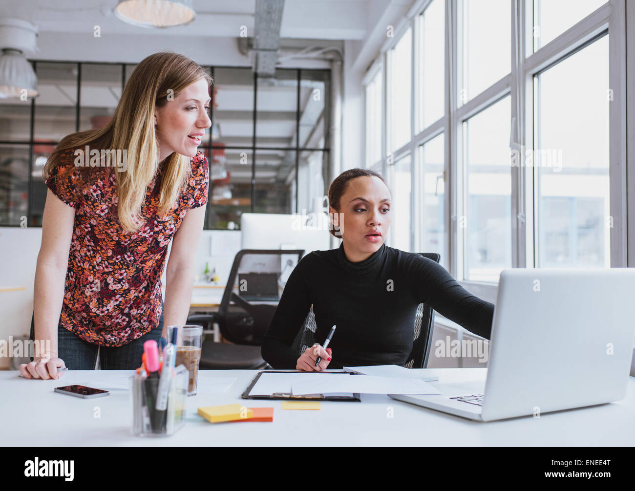 Weibliche Führungskräfte arbeiten gemeinsam an neuen Projekt. Kreativteam mit Laptop für Informationen im Büro. Stockfoto