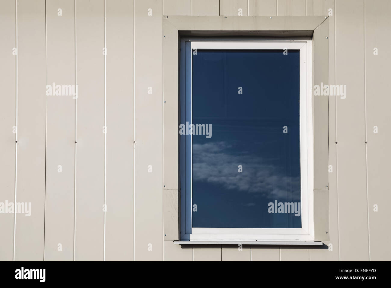 Fenster mit Himmel Reflexion in hellgelber Farbe Kunststoff siding Paneele Wand Stockfoto