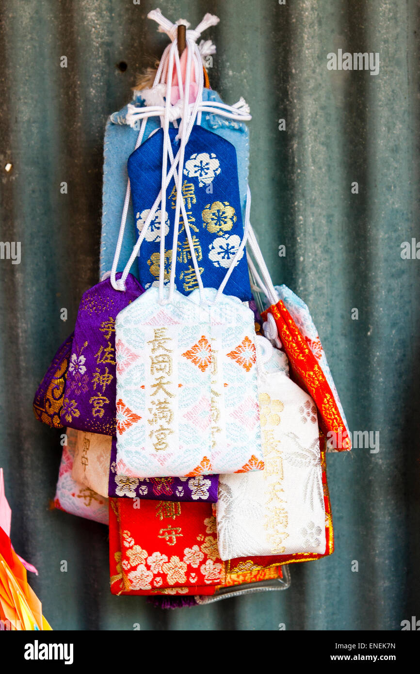 Mehrere winzige Kordelzug wie kleine Taschen, omamori, hängen an einem japanischen Schrein. Das Design dieser schützenden Reize stammt aus der Heian-Ära. Stockfoto