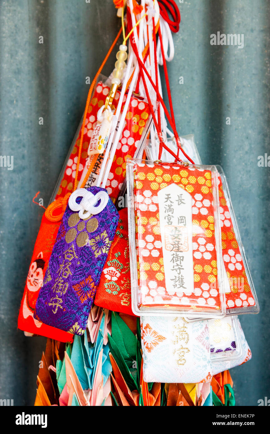 Mehrere winzige Kordelzug wie kleine Taschen, omamori, hängen an einem japanischen Schrein. Das Design dieser schützenden Reize stammt aus der Heian-Ära. Stockfoto