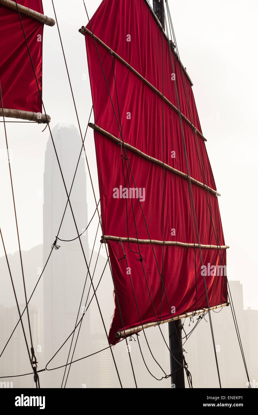 Hong Kong traditionelle rote Leinwand Segel, Rigg und Mast von einem alten Boot und moderne Skyline im Hintergrund Stockfoto