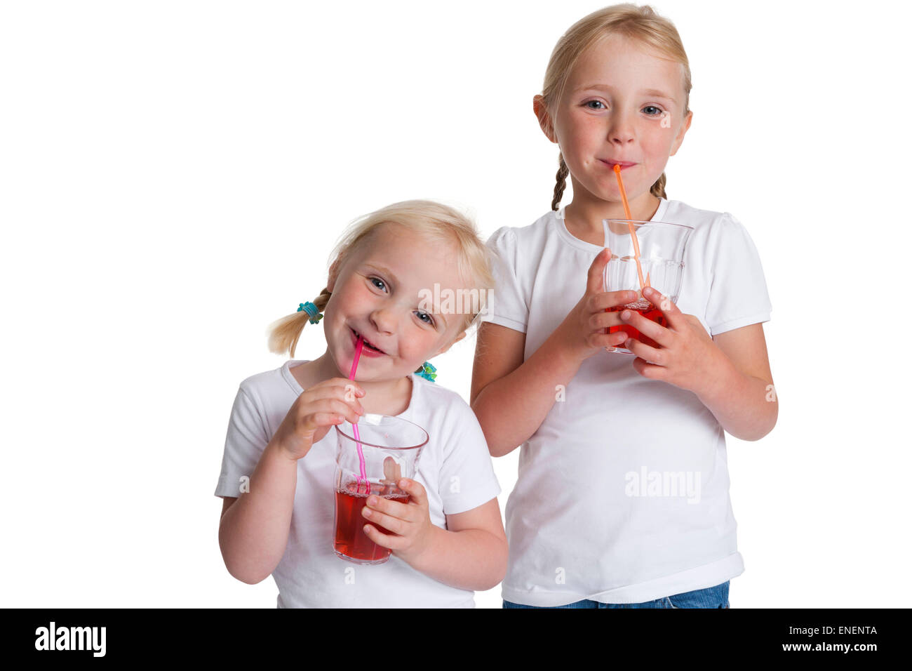 Porträt von zwei blonden Schwestern trinken rote Limonade mit einem Strohhalm auf weißem Hintergrund Stockfoto
