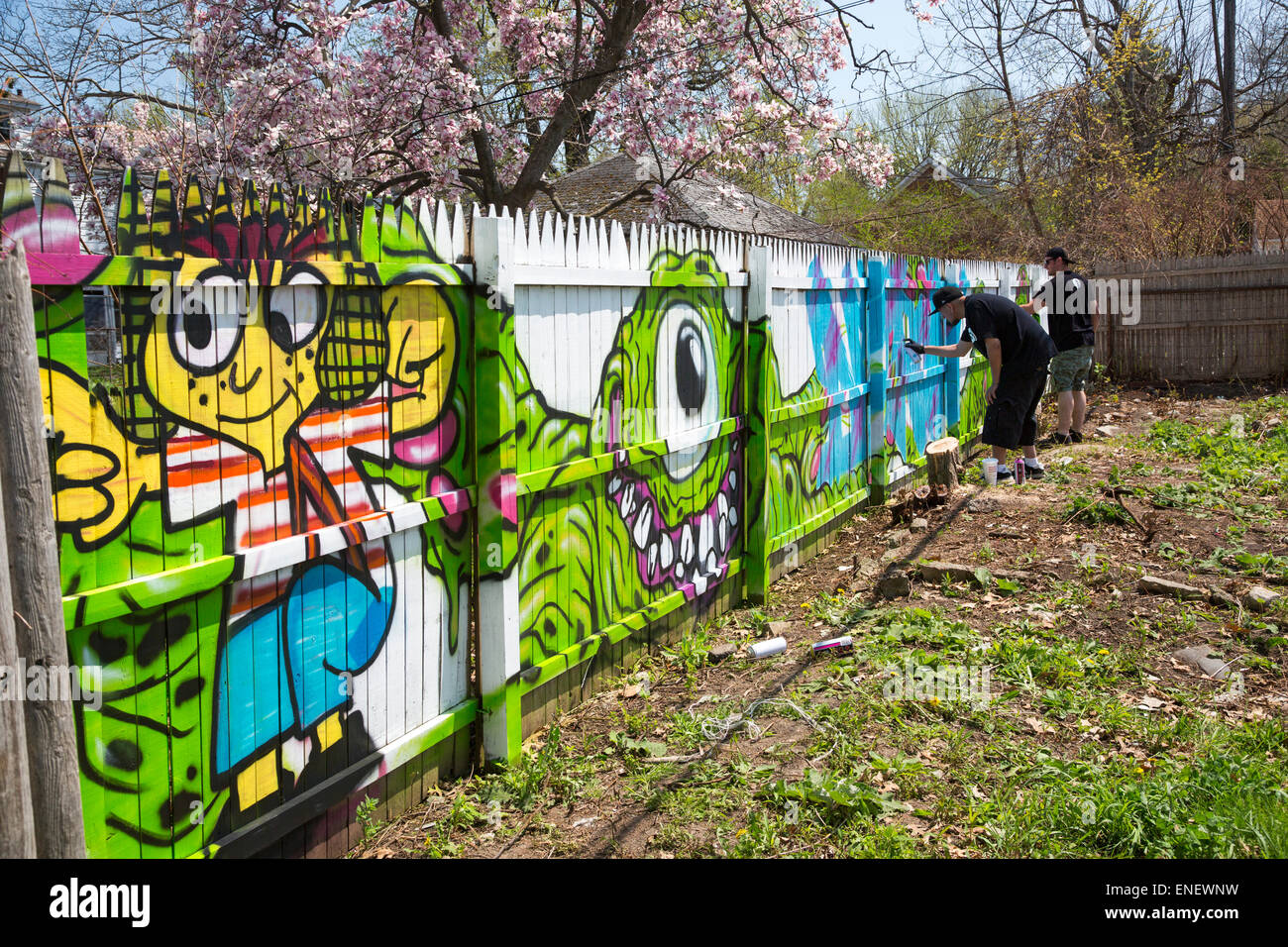 Detroit, Michigan - Künstler auf der Straße malen ein Zaun auf Baulücken, wo Häuser verlassen wurde und dann abgerissen. Stockfoto