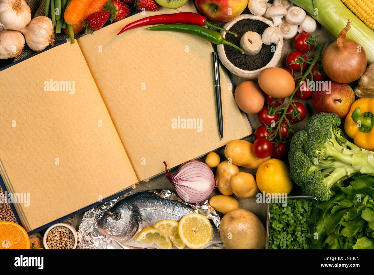 Grundnahrungsmittel - Obst, Fisch und Gemüse mit den leeren Seiten ein Rezeptbuch - Platz für Text. Stockfoto