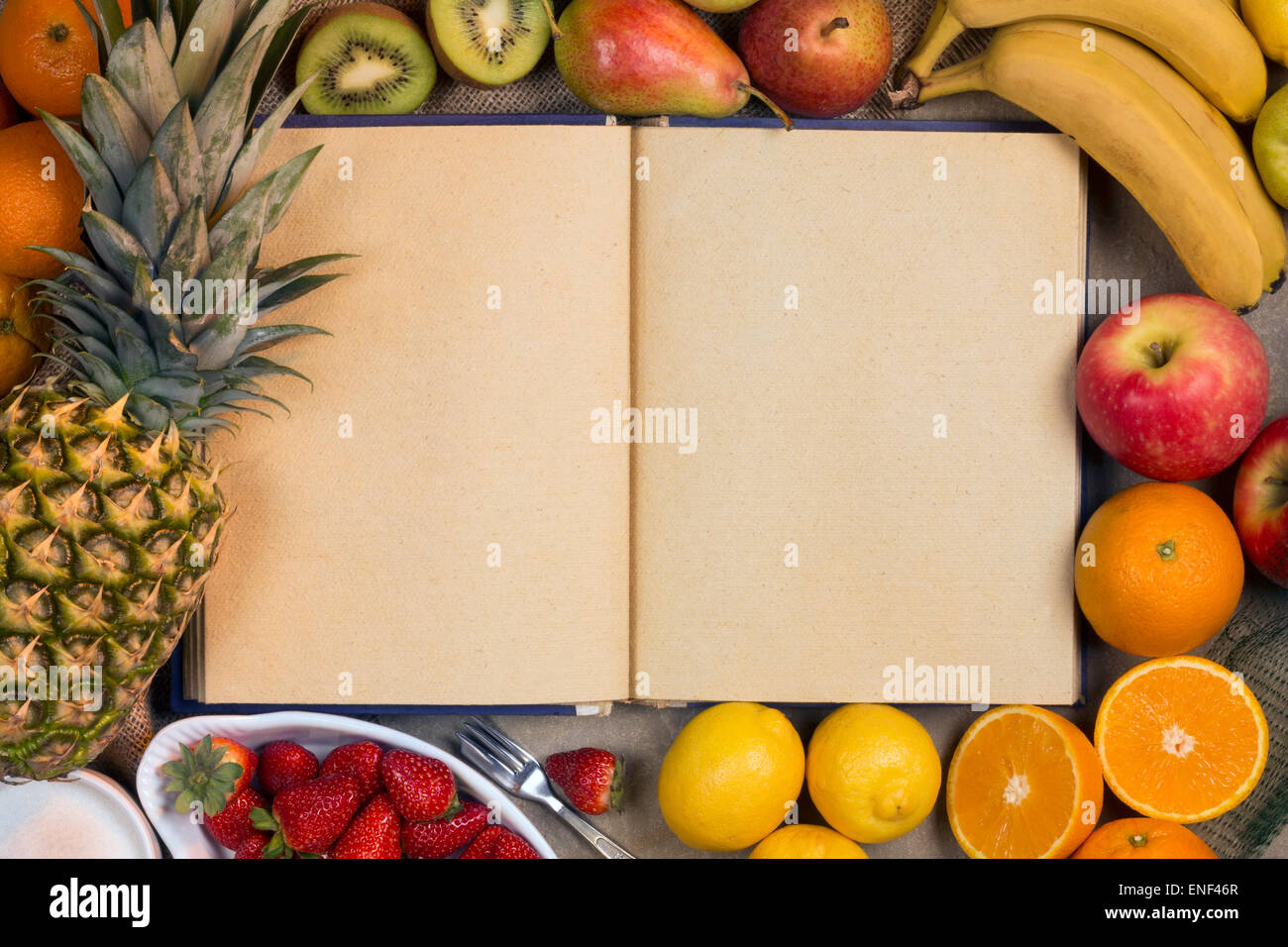 Eine Auswahl an frischem Obst und ein Rezeptbuch - Platz für text Stockfoto