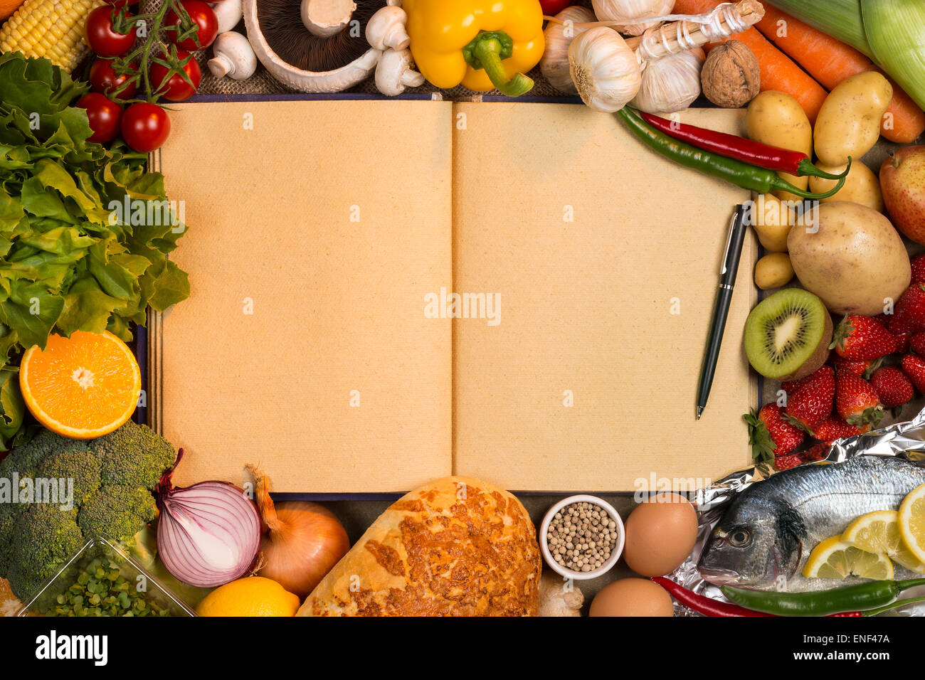 Grundnahrungsmittel - Obst, Fisch, Brot und Gemüse mit den leeren Seiten ein Rezeptbuch - Platz für Text. Stockfoto