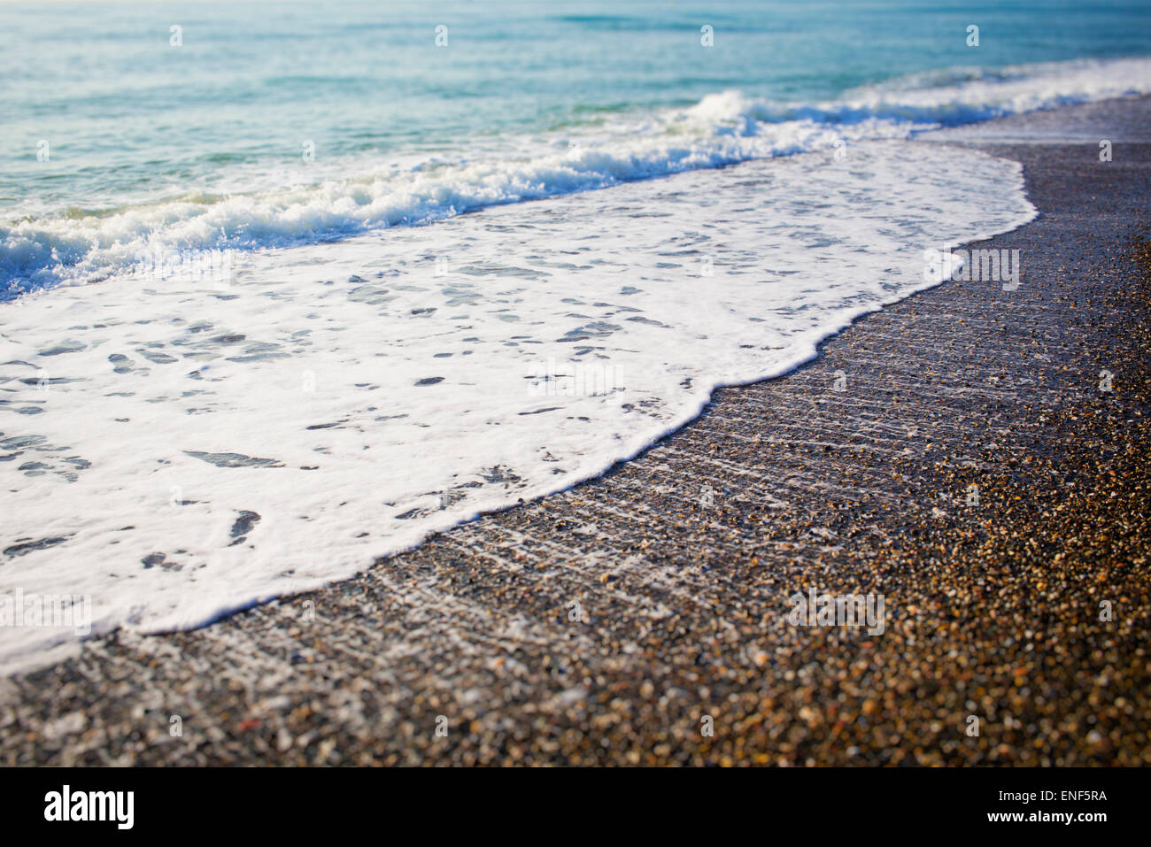 Wellen brechen sich am Strand. Stockfoto