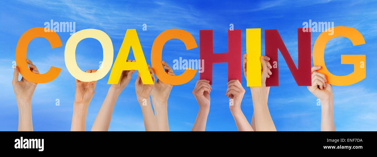 Hände halten bunte gerade Wort Himmel Coaching Stockfoto