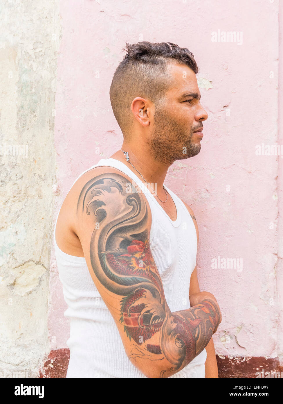 Ein 20-29 jährige kubanische Hispanic Mann zeigt seine tätowierten Oberarm in Havanna Vieja. Stockfoto