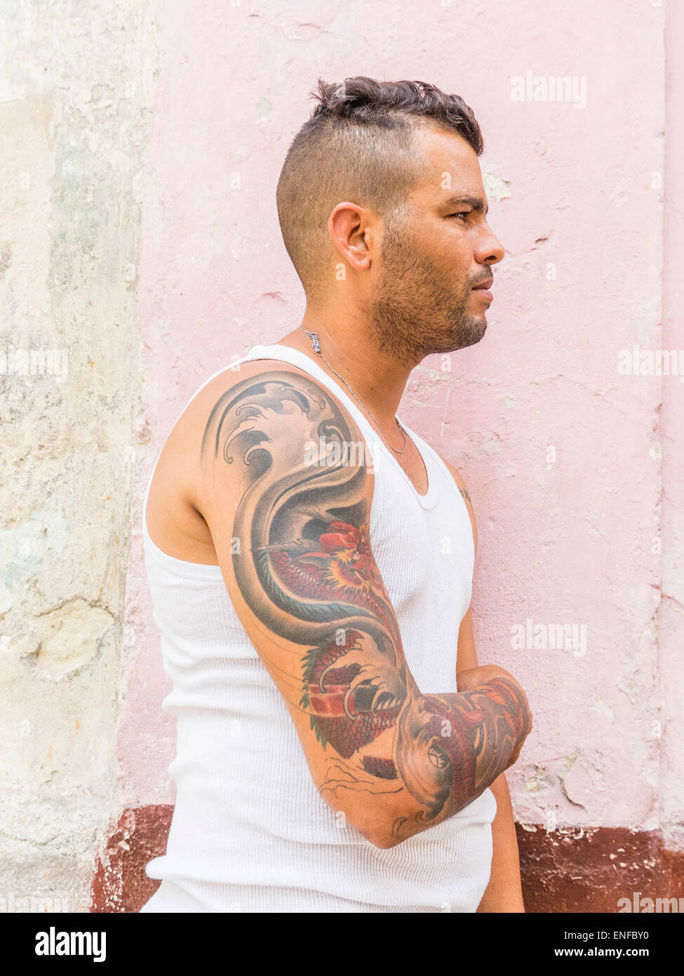 Ein 20-29 jährige kubanische Hispanic Mann zeigt seine tätowierten Oberarm in Havanna Vieja. Stockfoto