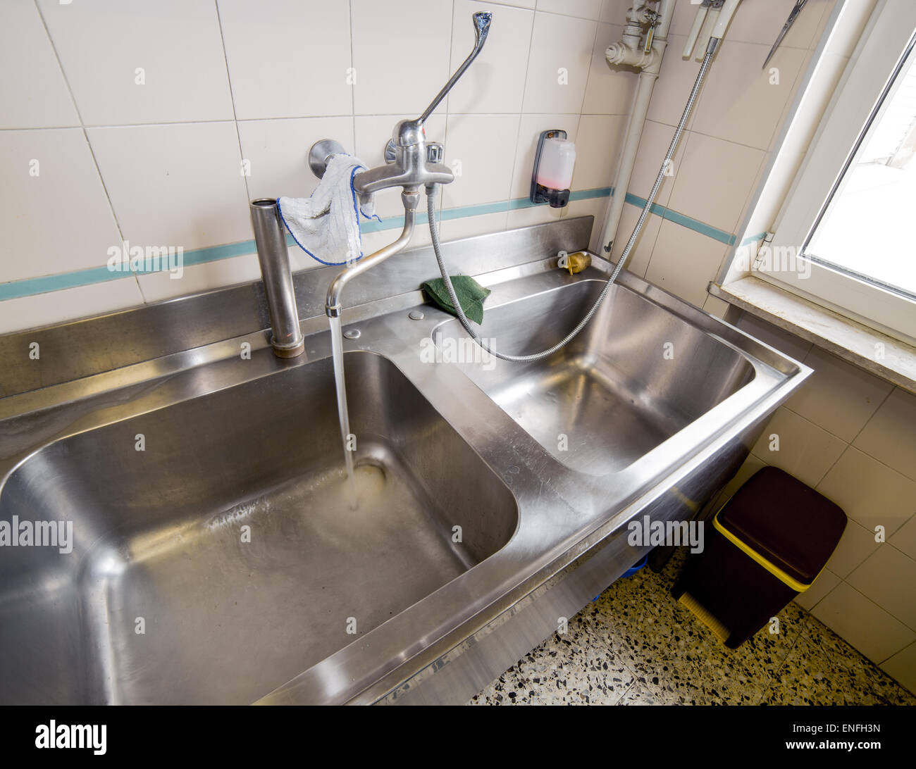 Großes Spülbecken aus Edelstahl Großküche mit Wasserhahn öffnen Stockfoto