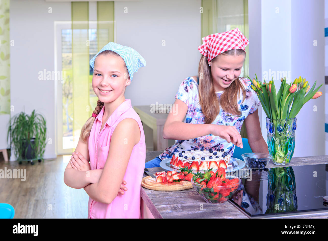 Mädchen im Teenageralter Backen eines Kuchens zu Hause mit frischen Früchten Stockfoto