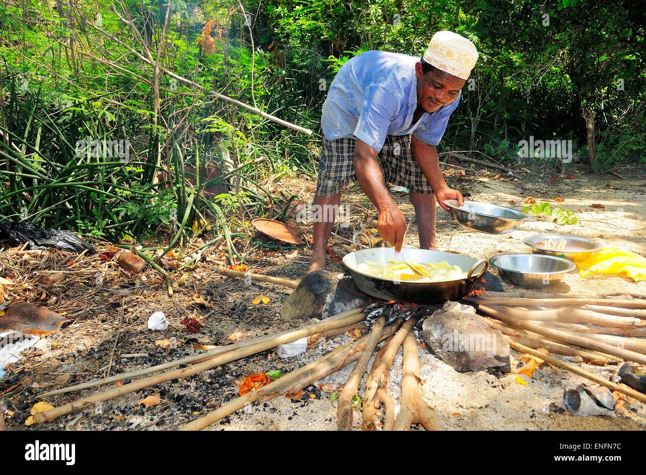 Mann beim Kochen Feuer am Strand Ilots Choizil, Mayotte Stockfoto