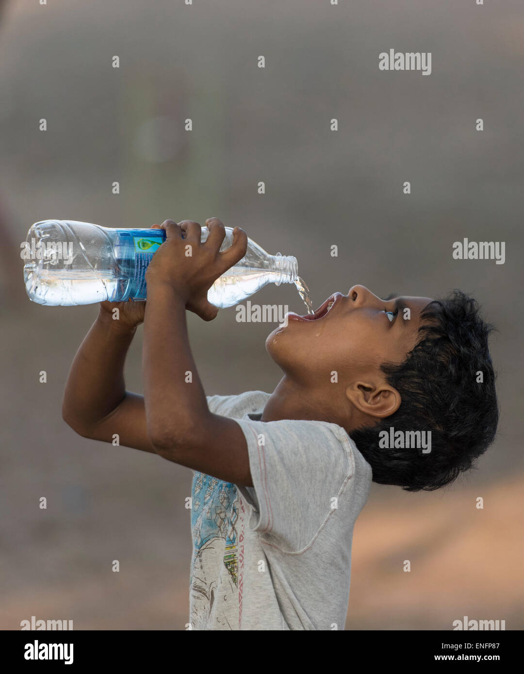 Junge Trinkwasser aus einer Plastikflasche, Fort Cochin, Kochi, Kerala, Indien Stockfoto