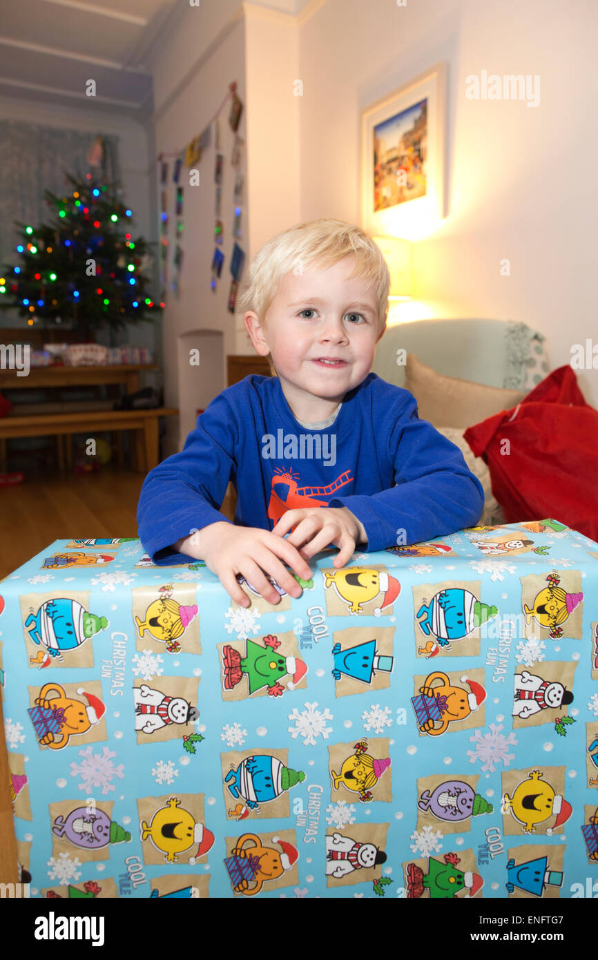 Vier Jahre alter Junge, zu Hause am Weihnachtstag mit auf seine Weihnachtsgeschenke, England, UK Stockfoto