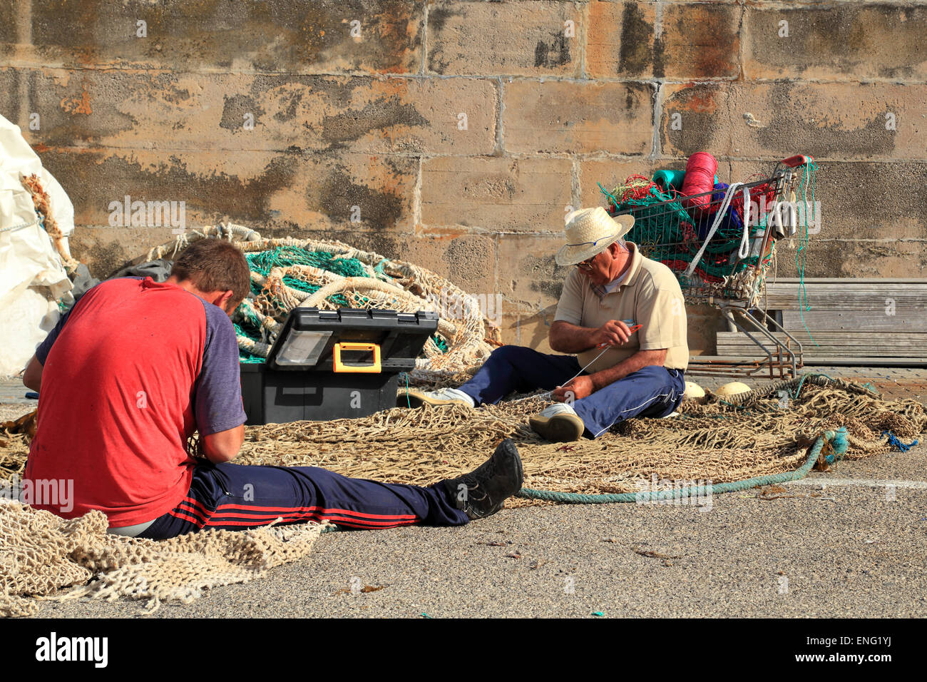 Fischer reparieren ihre Fischernetz, Hafen von Cala Rajada Stockfoto