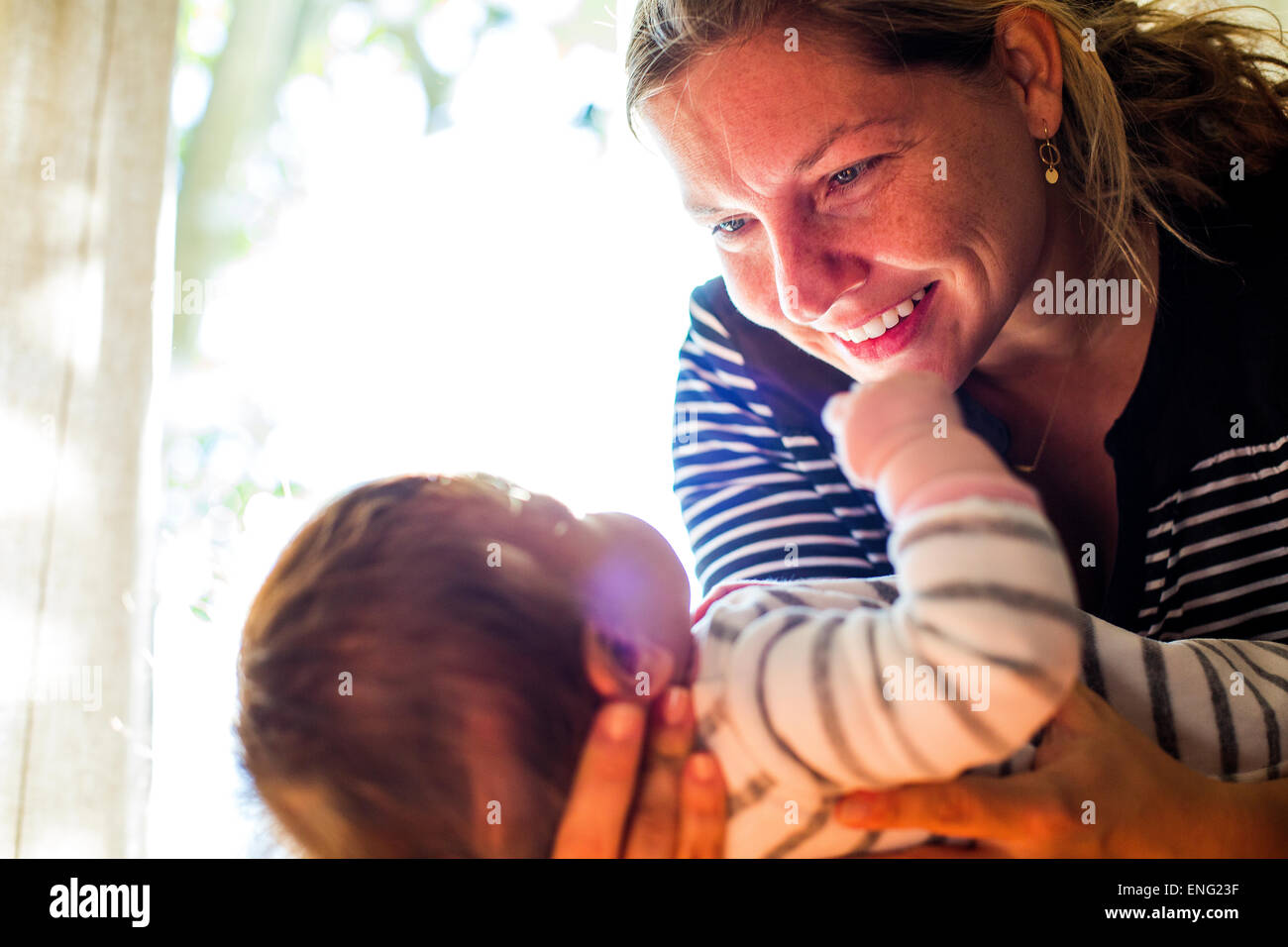 Lächelndes kaukasischen Mutter wiegt Babymädchen Stockfoto