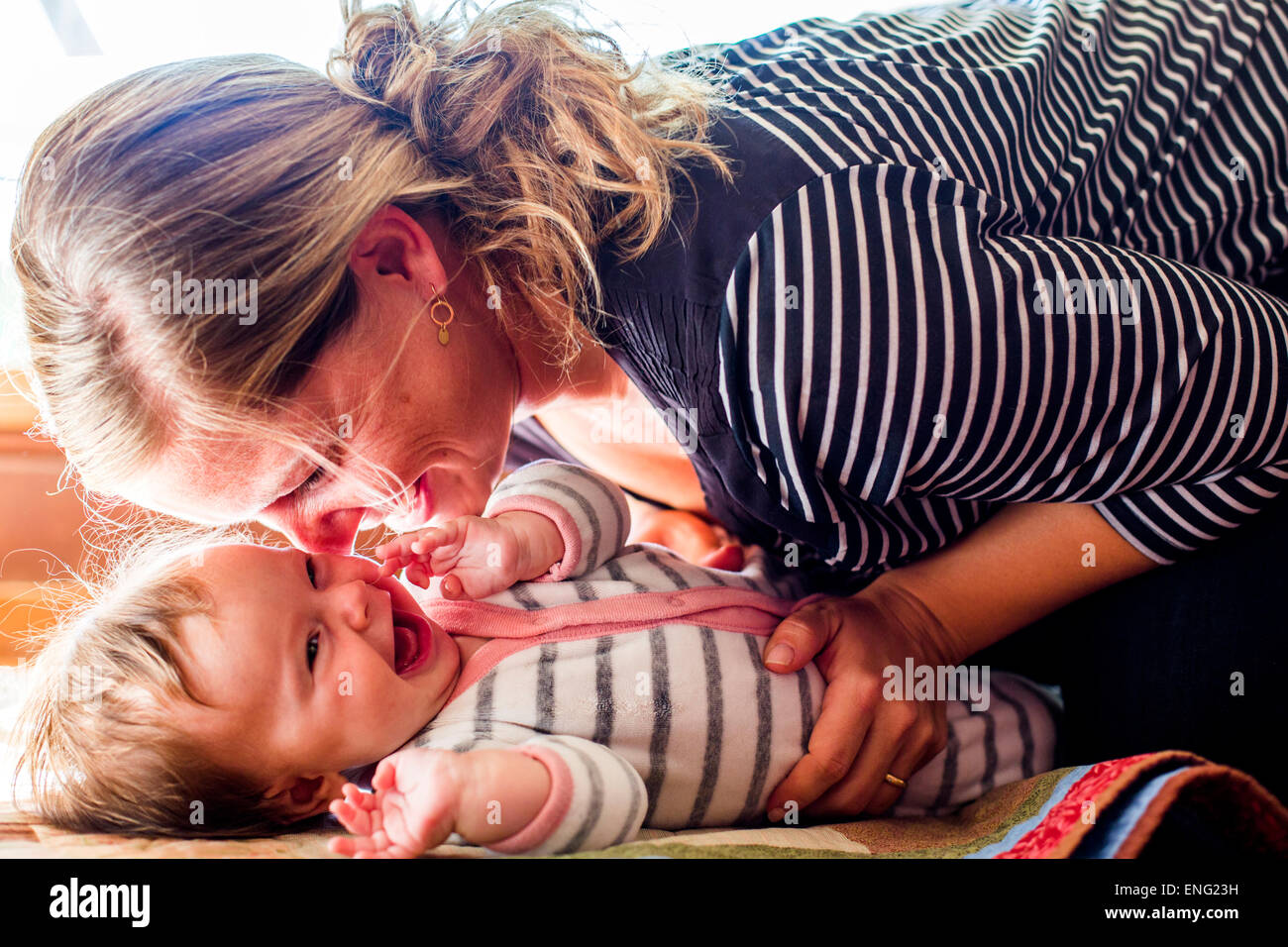 Lächelndes kaukasischen Mutter wiegt Babymädchen Stockfoto