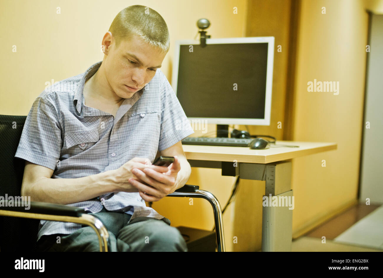 Kaukasischen Mann mit Handy am Computer-Schreibtisch Stockfoto