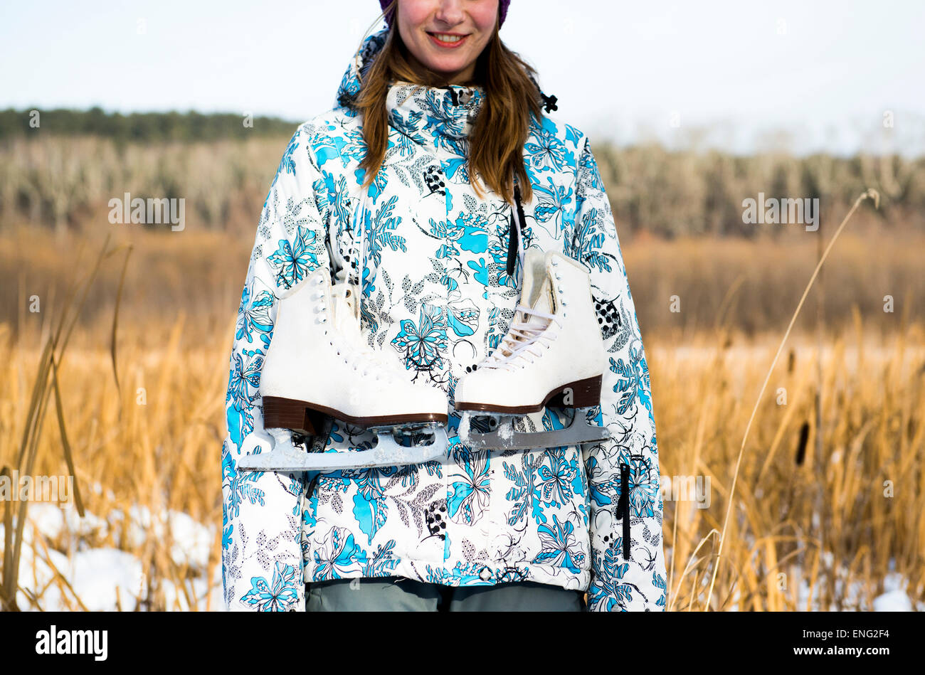 Kaukasische Frau mit Schlittschuhen im Feld Stockfoto