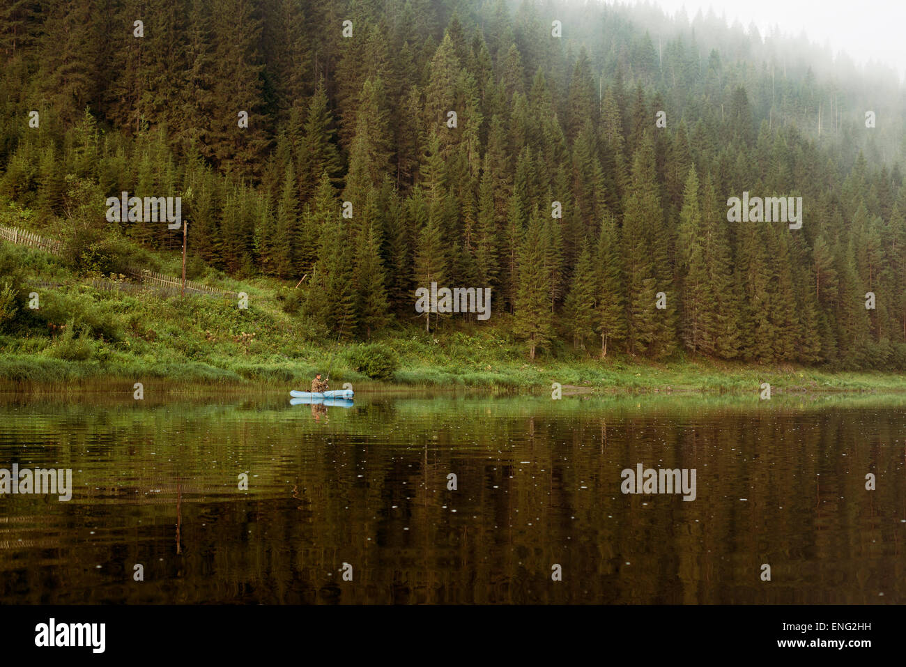 Kaukasischen Mann Rudern Kanu in abgelegenen See Stockfoto