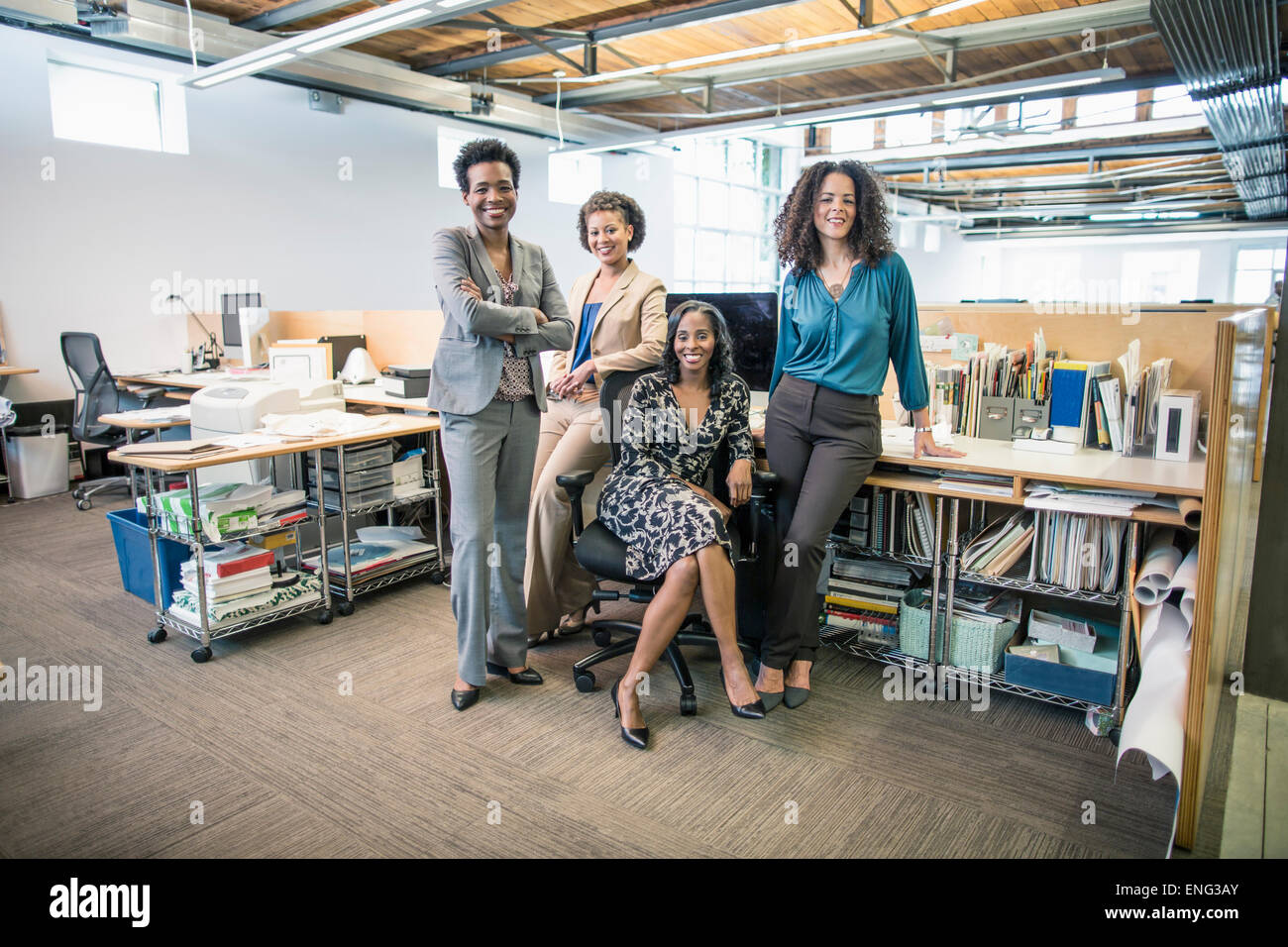 Geschäftsfrauen, die lächelnd am Schreibtisch im Büro Stockfoto