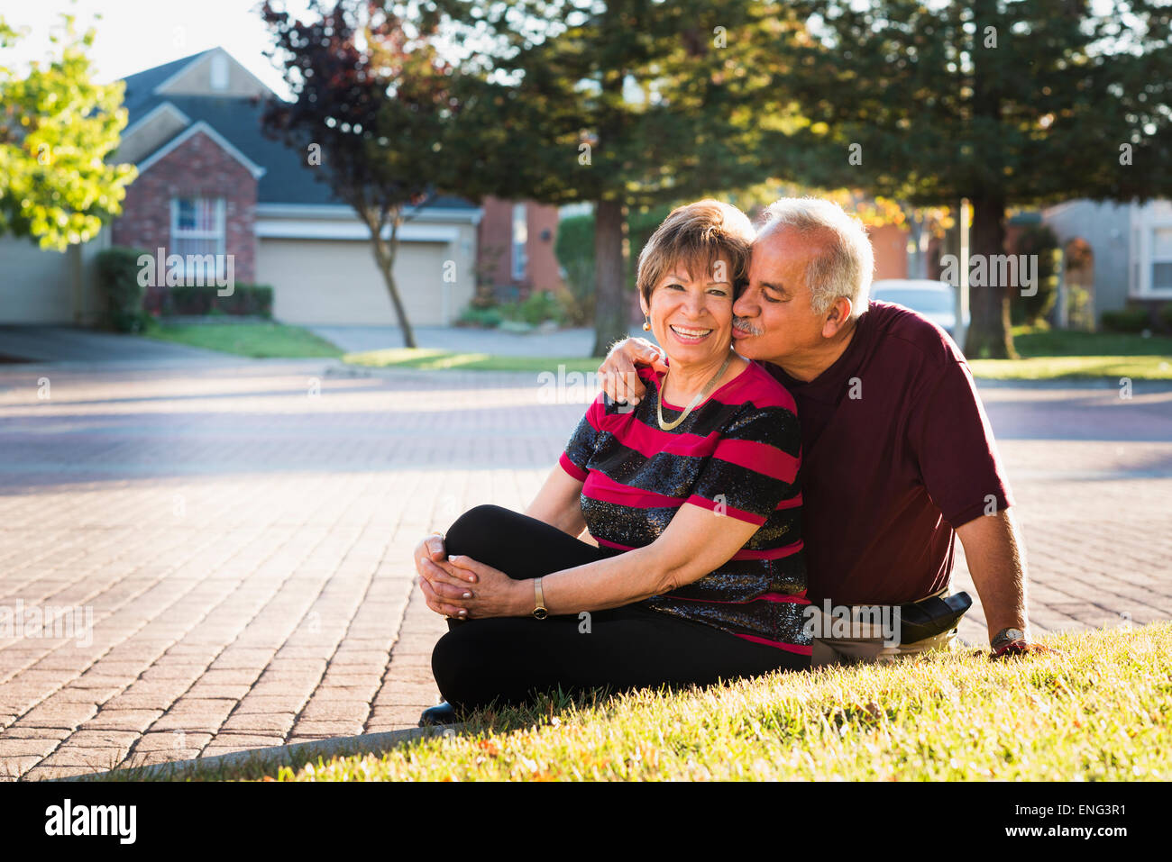Ältere Hispanic paar küssen außerhalb Vorstadthaus Stockfoto