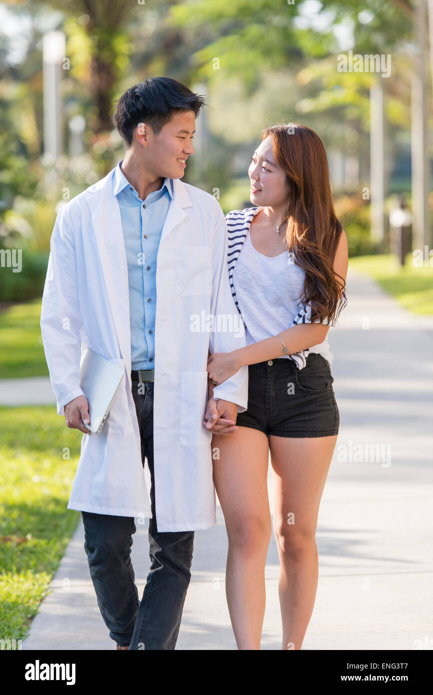 Koreanischen Arzt zu Fuß mit Freundin auf Bürgersteig Stockfoto