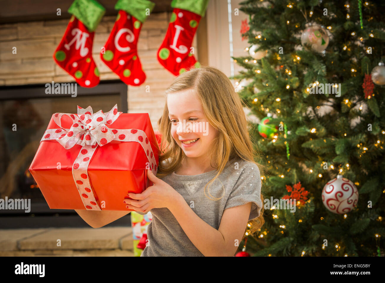 Kaukasische Mädchen untersuchen Weihnachtsgeschenk Stockfoto