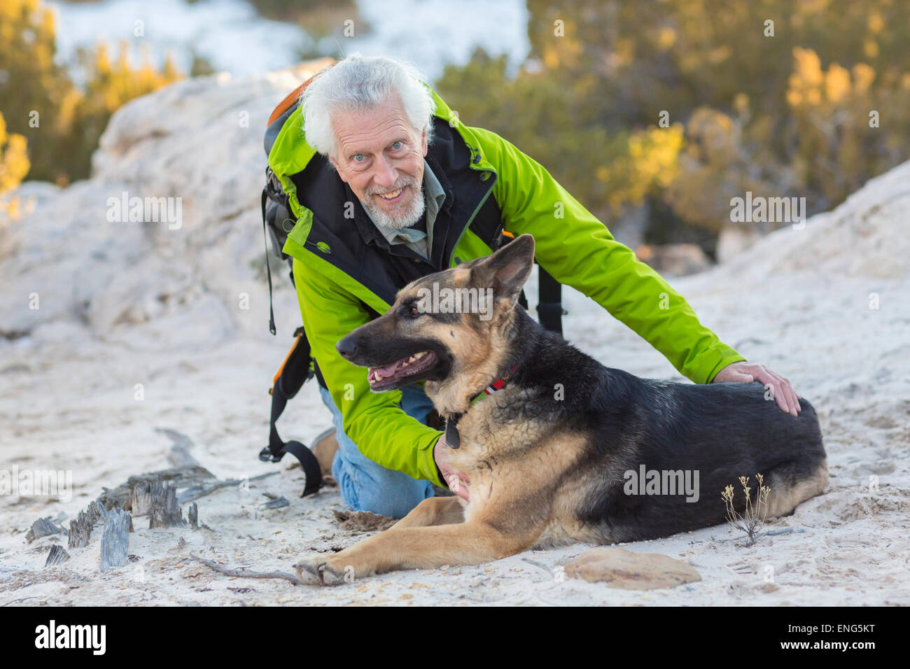 Ältere Mann Petting Hund auf felsigen Hügel Stockfoto