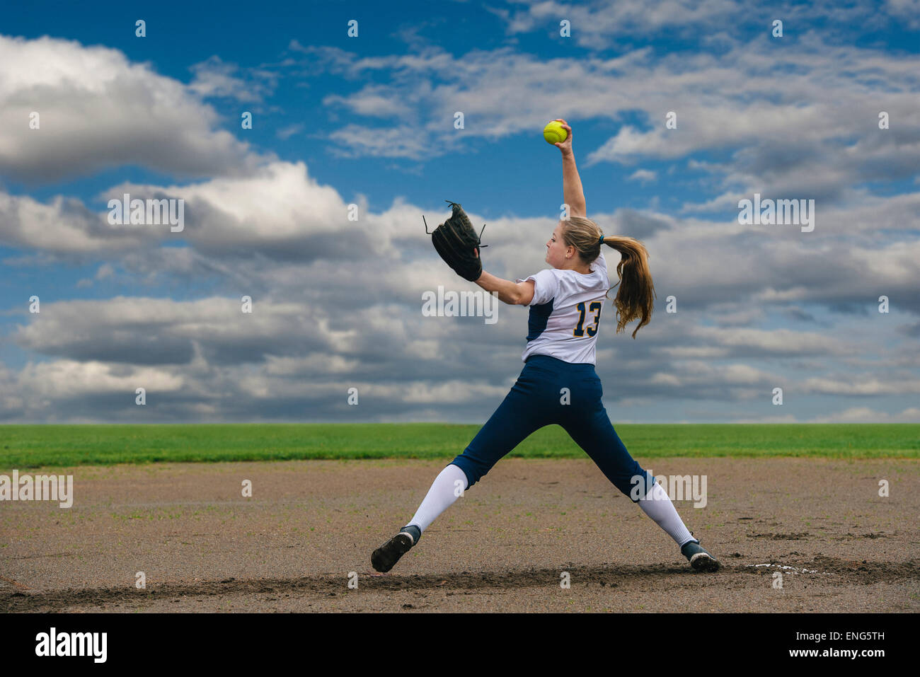 Kaukasische Softball Spieler pitching Ball im Feld Stockfoto