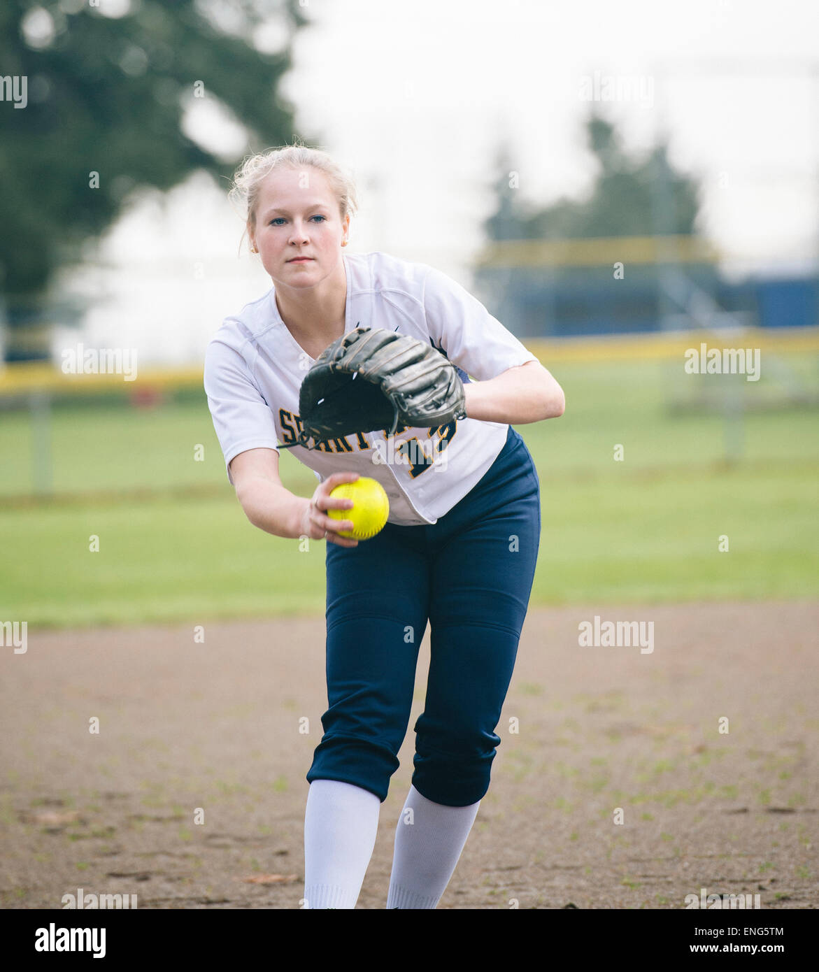 Kaukasische Softball Spieler pitching Ball im Feld Stockfoto