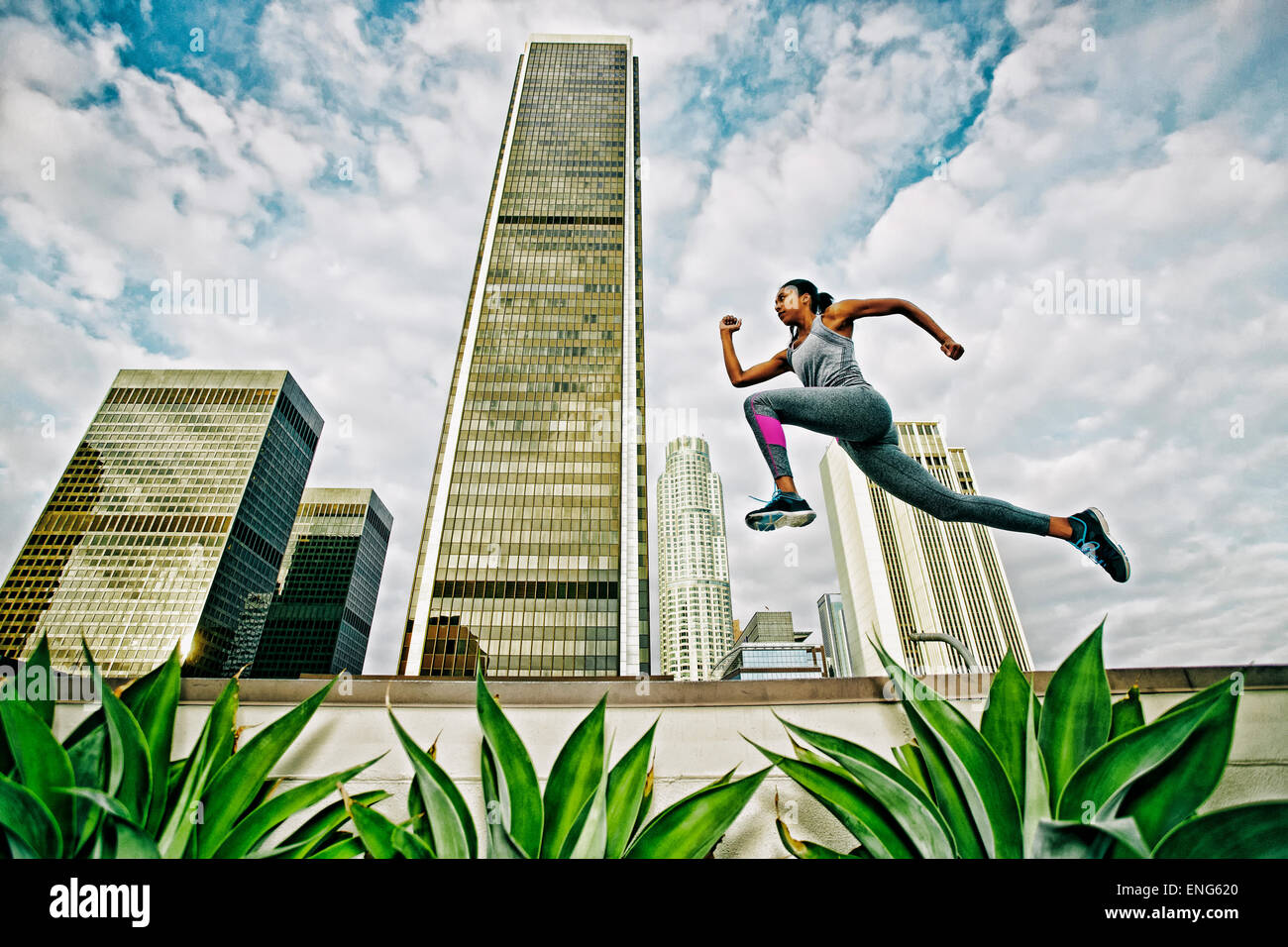 Afrikanische amerikanische Frau auf städtischen Dach springen Stockfoto