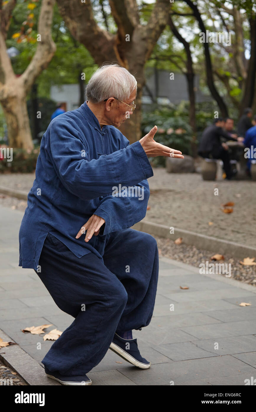 Ein reifer Mann, der taiji quan (oder taichi) in einem Stadtpark praktiziert; Renmin Park, Shanghai, China. Stockfoto