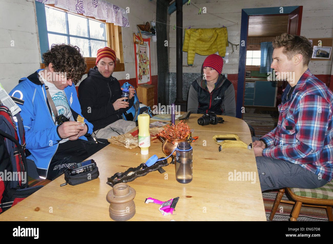 Vier Männer sitzen um einen Tisch, eine Alpine Essen in der Skihütte Skihutte nahe Lynseidet Lyngen Alpen (Lyngsalpene) Norwegen Stockfoto