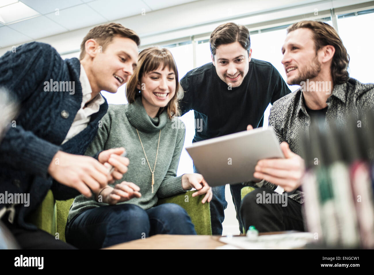 Vier Menschen, Kollegen bei einem Treffen und ein Mann, einen Tablet mit der Gruppe teilen. Stockfoto